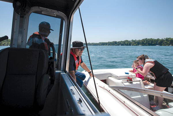 Petty Office William Moore (center), a boarding officer at USCG Station Niagara, speaks with a boater during a safety boarding on the Niagara River during Operation Dry Water