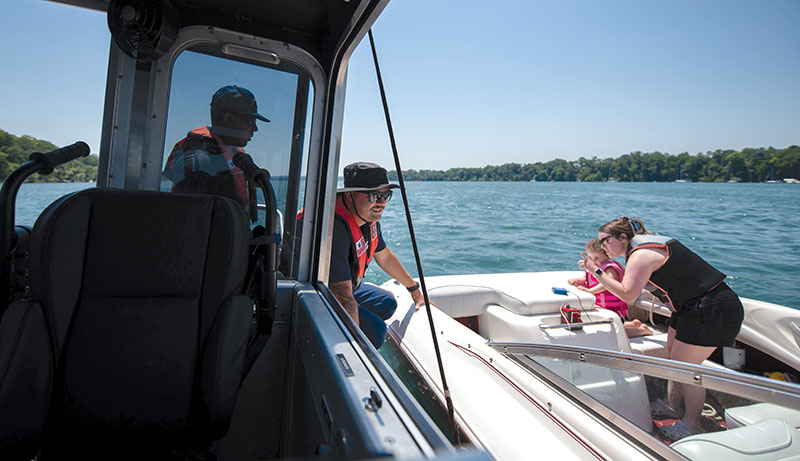 Petty Office William Moore (center), a boarding officer at USCG Station Niagara, speaks with a boater during a safety boarding on the Niagara River during Operation Dry Water